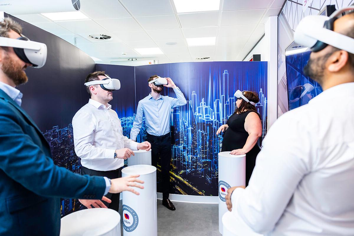 A group of people wearing white virtual reality (VR) headsets in the Mitie Cleaning and Hygiene Centre of Excellence, to experience virtual cleaning environments and training